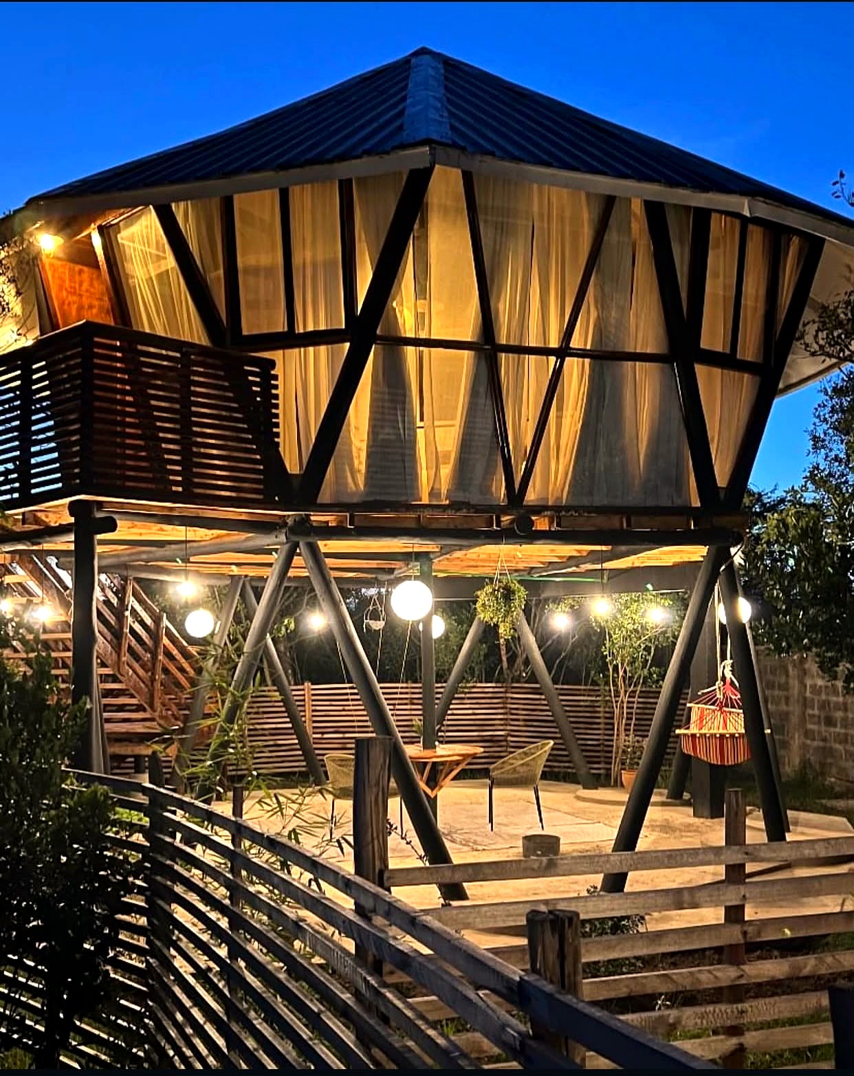 The Daiga Suite at dusk, with string lights and mountain views